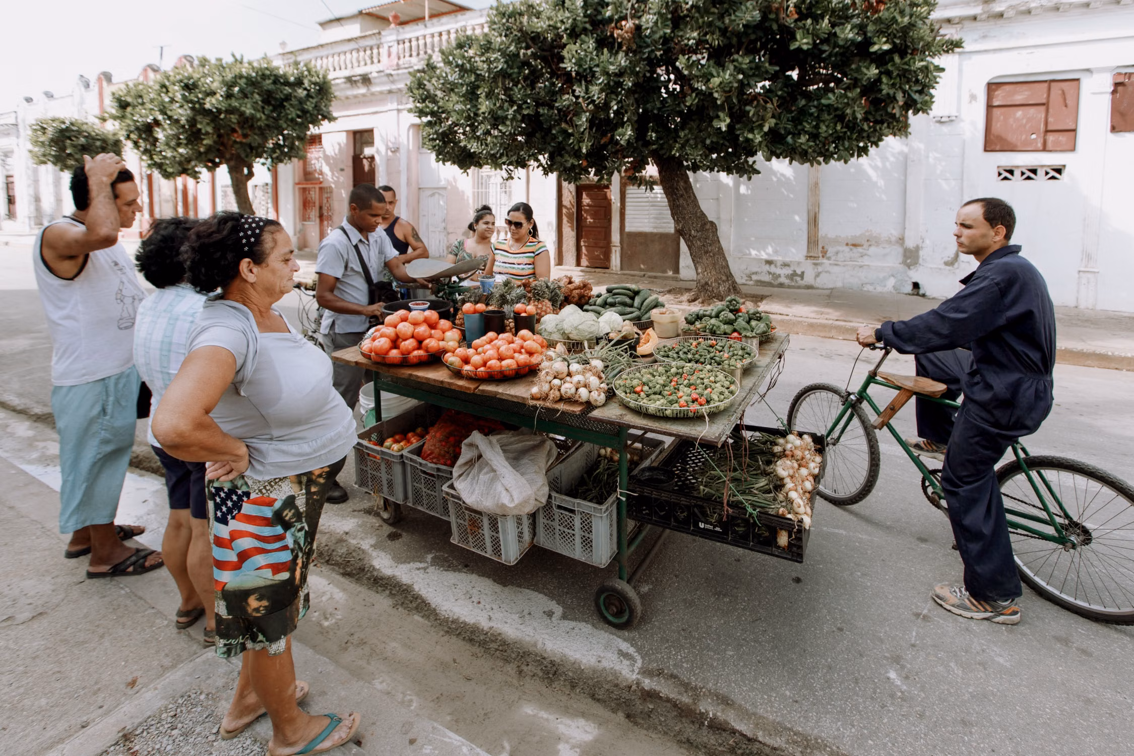 Pessoas comprando verduras em uma feira de rua